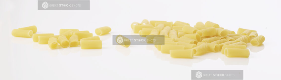 uncooked rigatoni pasta on a white background