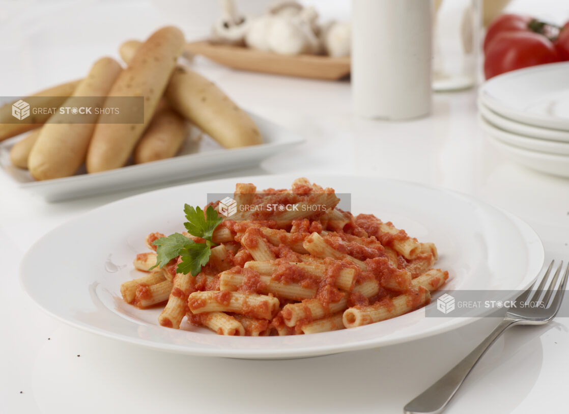 mini rigatoni with marinara sauce and a side of garlic bread sticks