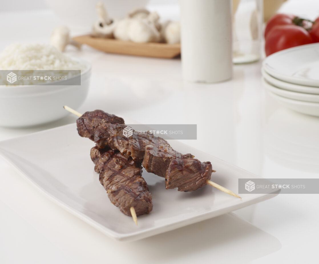 Grilled beef skewer on a white plate