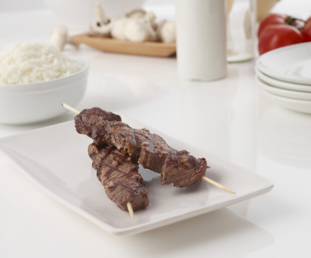 Grilled beef skewer on a white plate