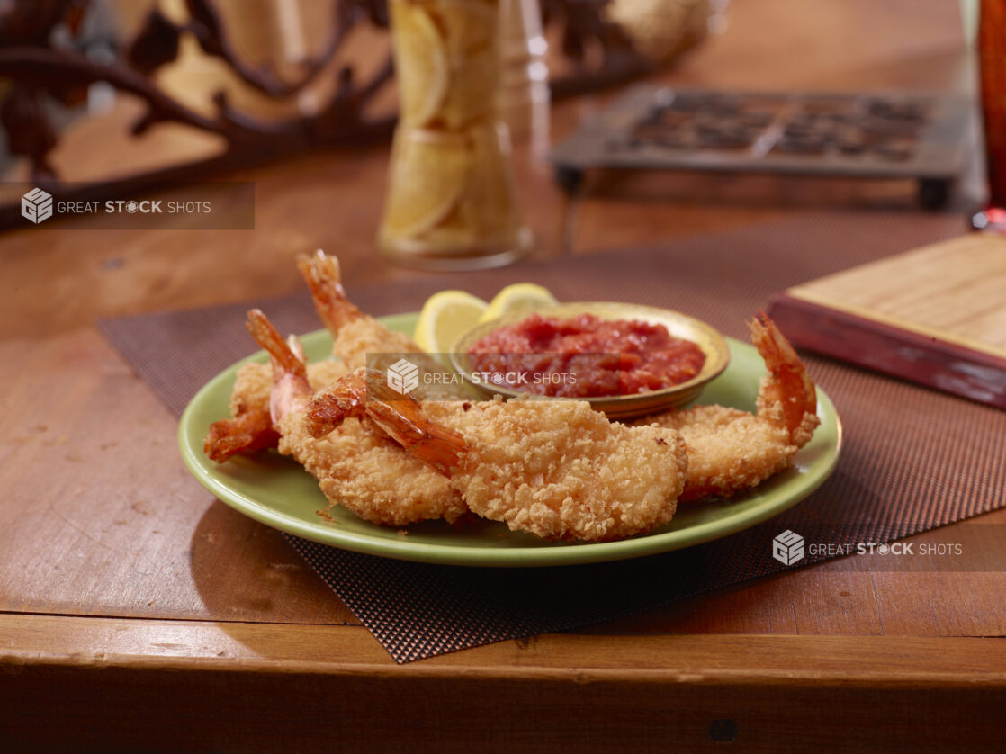 Breaded Shrimp with a Side of Cocktails Sauce on a Wooden Table in a Restaurant Setting