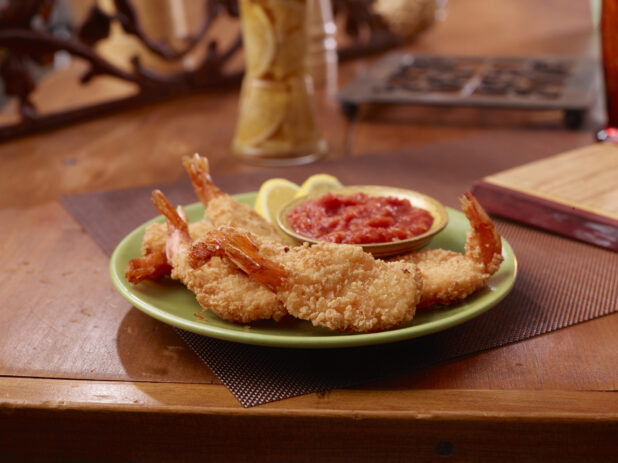 Breaded Shrimp with a Side of Cocktails Sauce on a Wooden Table in a Restaurant Setting