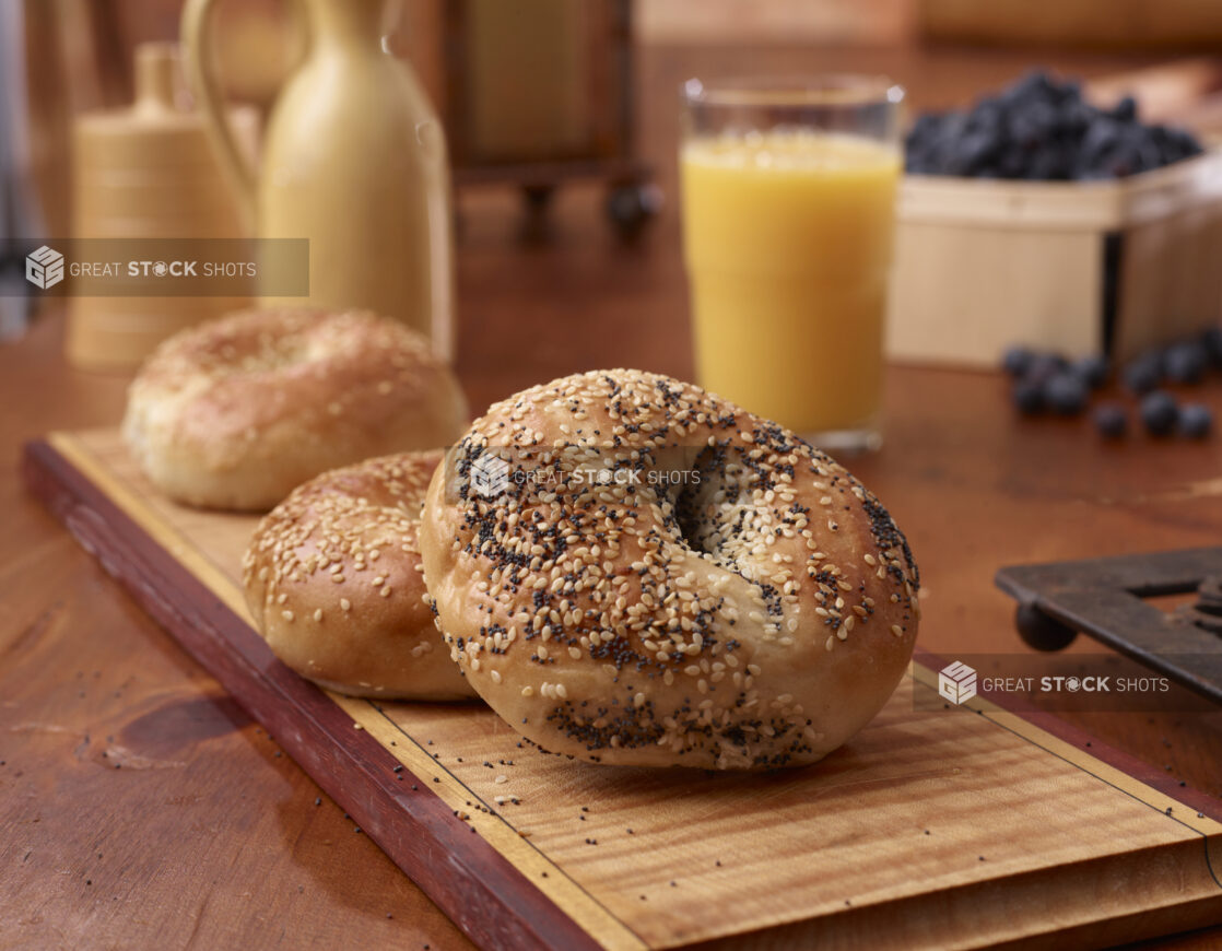 Close Up of Sesame and Poppy Seed Bagels on a Wood Board in an Indoor Kitchen Setting - Variation