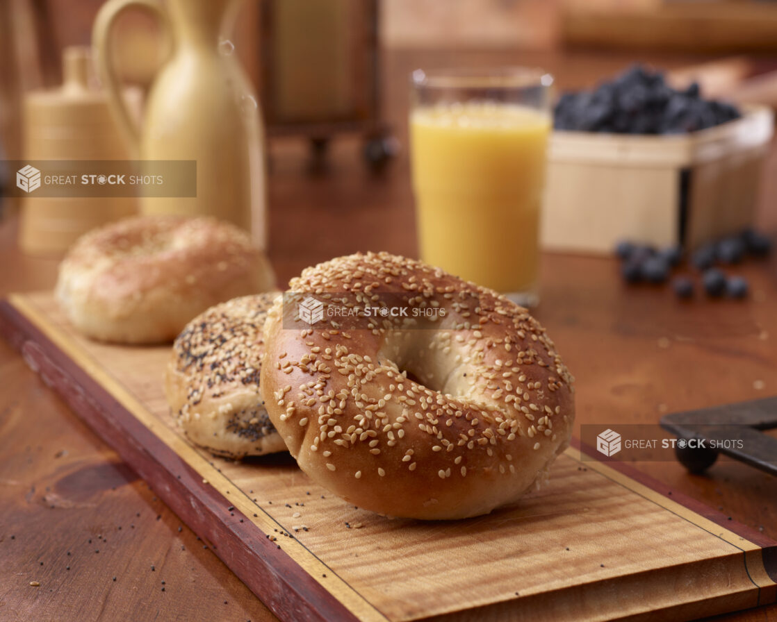 Close Up of Sesame and Poppy Seed Bagels on a Wood Board in an Indoor Kitchen Setting