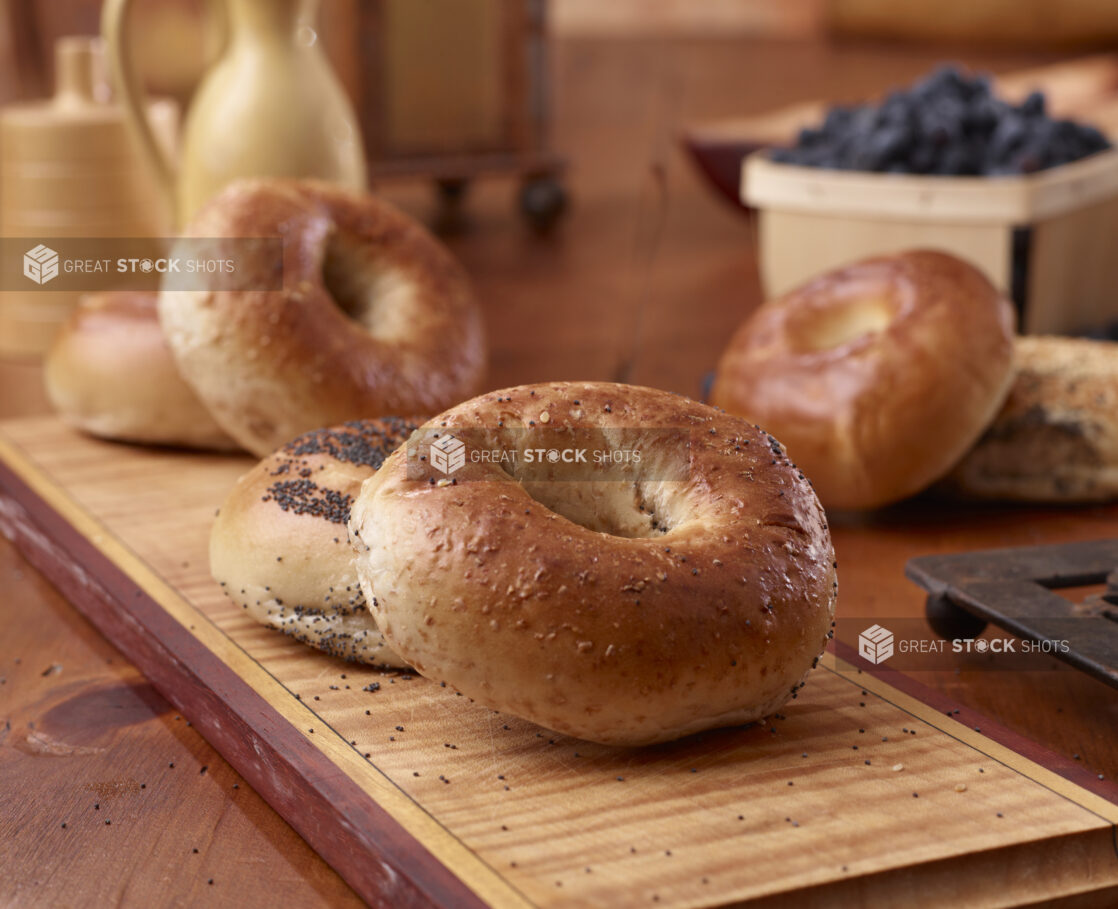 Close Up of Whole Wheat and Poppy Seed Bagels on a Wood Board in an Indoor Kitchen Setting