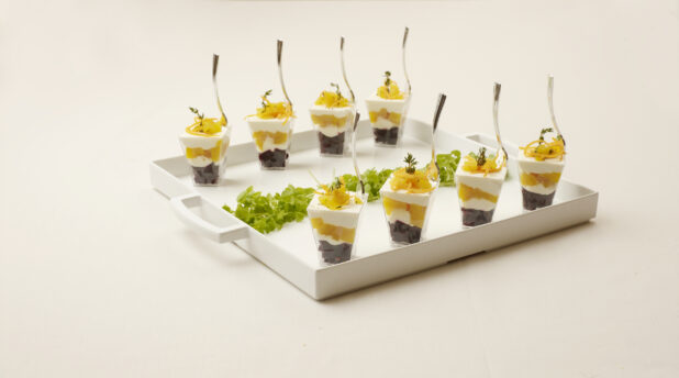 Mini Mango and Berry Parfaits in See Through Cups on a White Catering Platter with Handles on a Beige Surface - for Catering
