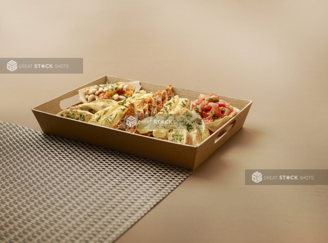 Platter of Assorted Breads, Flatbreads and Bread Sticks with Tomato and Bean Salsas in a Wooden Tray for Catering