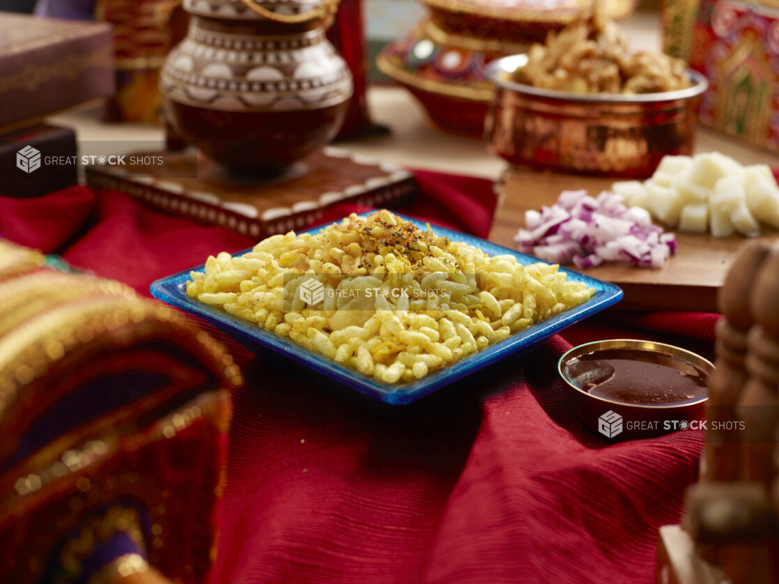 Indian Deep Fried Puff Snacks - Ompodi - with Ingredients on a Red Table Cloth in an Indoor Setting