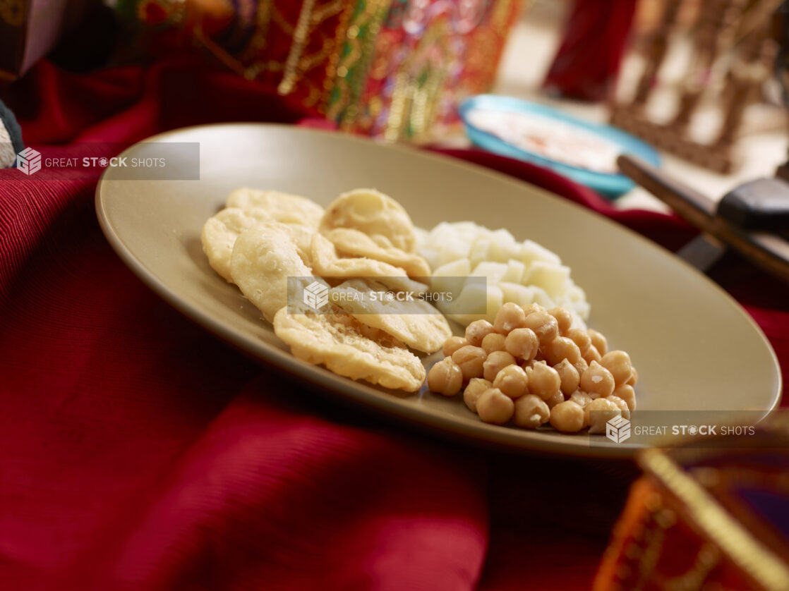 Indian Breakfast Plate of Chana Puri - Chickpea Curry with Puff Bread - in a Brown Ceramic Dish on a Red Tablecloth