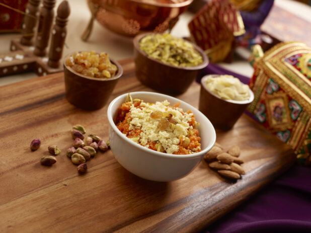 A Bowl of Gajar Ka Halwa - Indian Dessert Pudding Made of Grated Carrots, Milk and Ghee with Nuts and Dried Fruit Toppings
