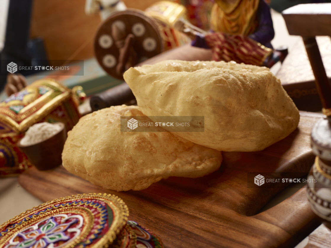 Close Up of Bhatura – Indian Deep Fried Sourdough Bread – on a Wooden Platter in an Indoor Setting