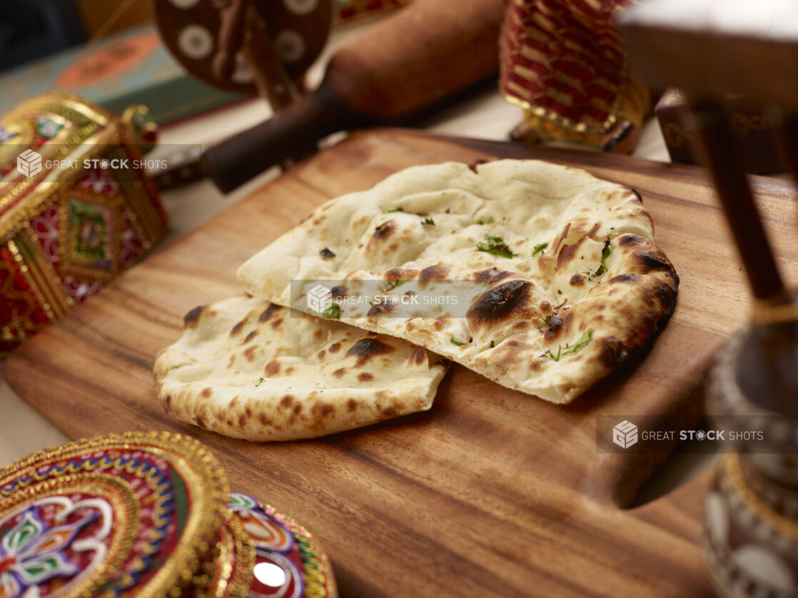 Oven-baked (Tandoor) Plain Naan – Indian Bread on a Wooden Cutting Board in an Indoor Setting