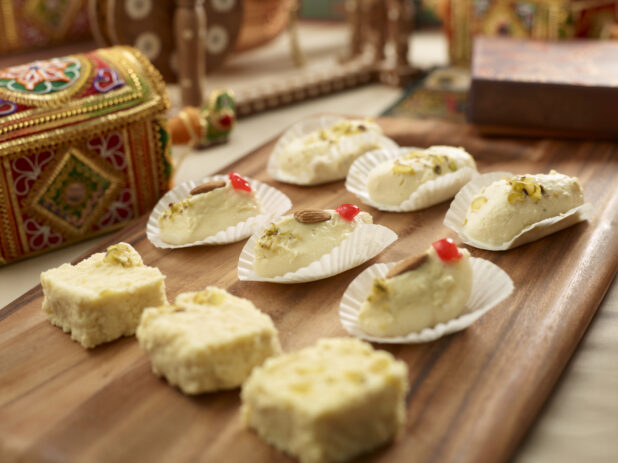 Kalakand - Indian Cheese-based Sweet - with Pistachio Garnish on a Wooden Platter in an Indoor Setting