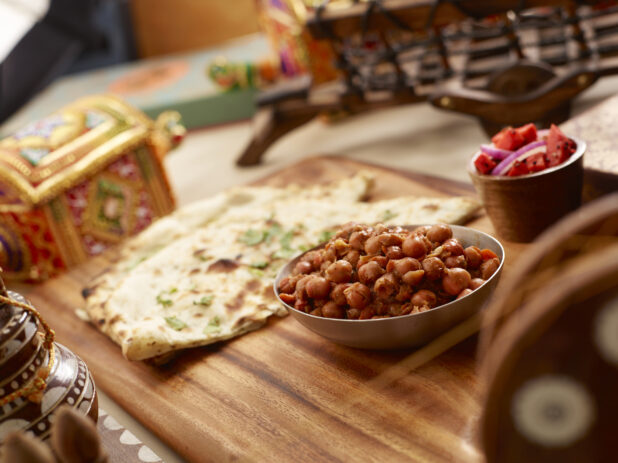 Indian Breakfast of Naan and Chana Masala - Spicy Chickpeas - with a Side Dish of Pickled Vegetables on a Wooden Platter in an Indoor Setting - Variation