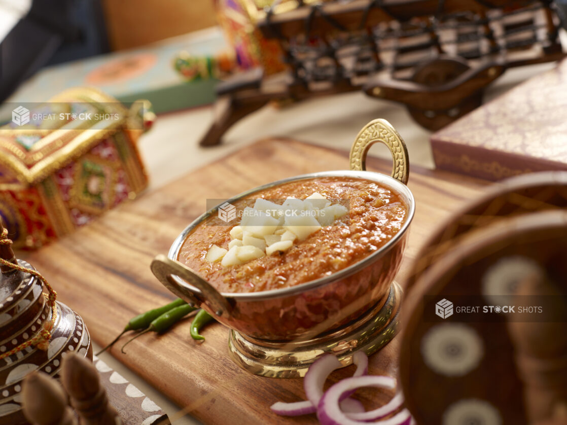 Copper Bowl of Bhaji - Thick Vegetable Curry - with Fresh Ingredients on a Wooden Platter in an Indoor Setting