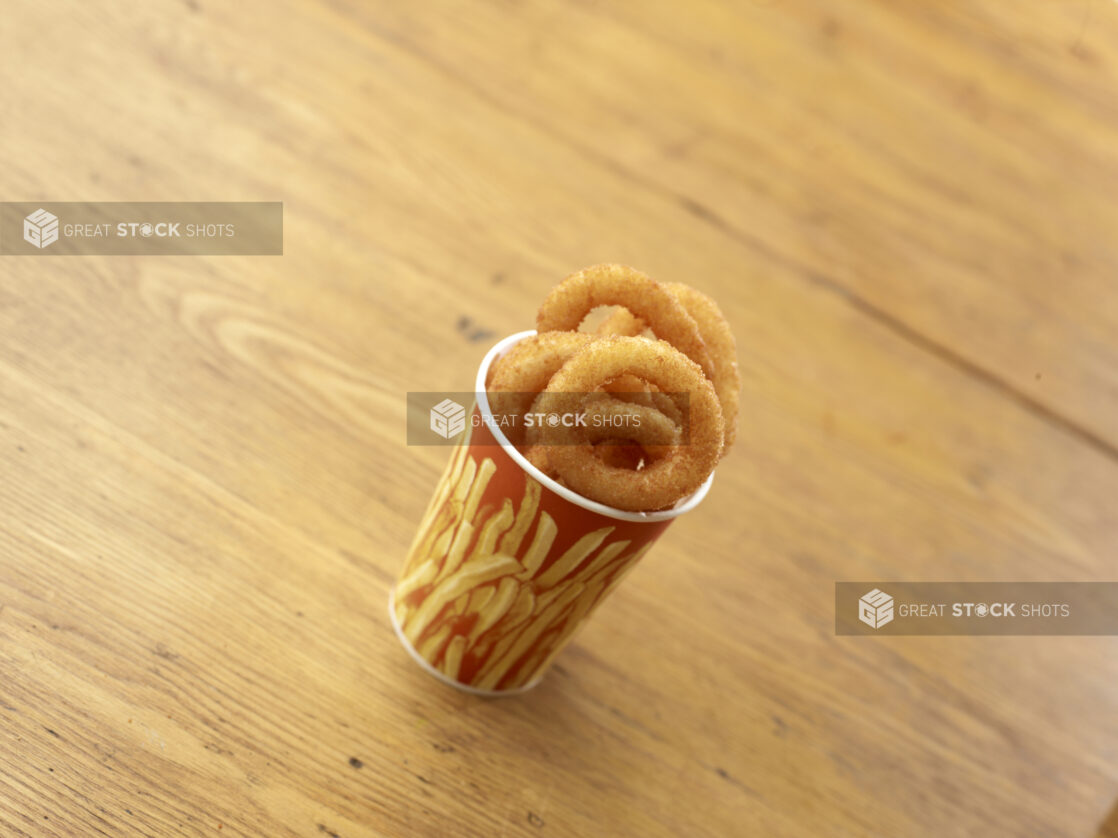 Cardboard Cup of Fried Onion Rings on a Rustic Untreated Wood Surface