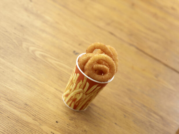 Cardboard Cup of Fried Onion Rings on a Rustic Untreated Wood Surface