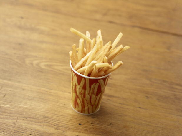 Cardboard Cup of Plain Thin-Cut French Fries on a Rustic Untreated Wood Surface