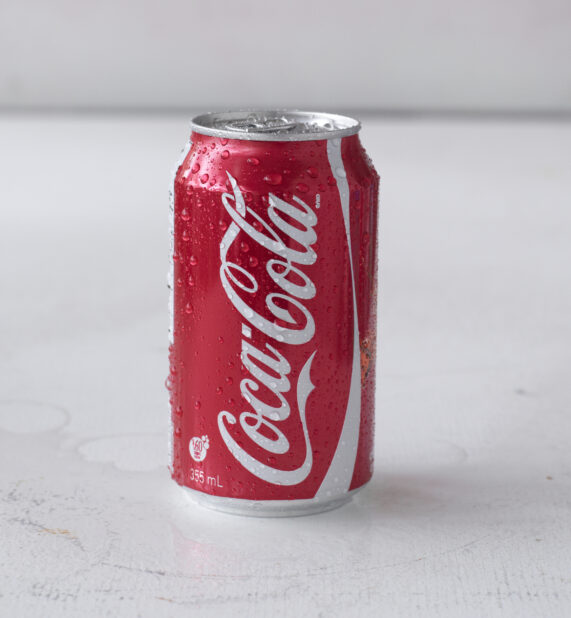 Close Up of a Can of Coca-Cola on a White Surface in an Indoor Setting