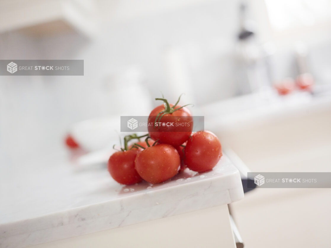 Fresh Tomatoes Stacked on Marble Counter with Bokeh Background