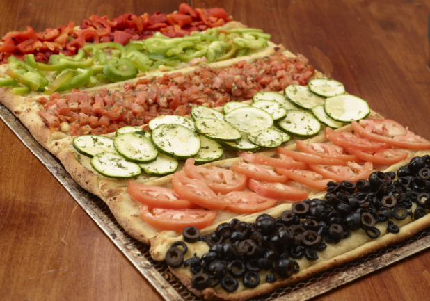 Flatbread Pizza with Assorted Fresh and Roasted Vegetable Toppings: Sliced Tomatoes, Black Olives, Bruchetta, Zucchini on a Wooden Table