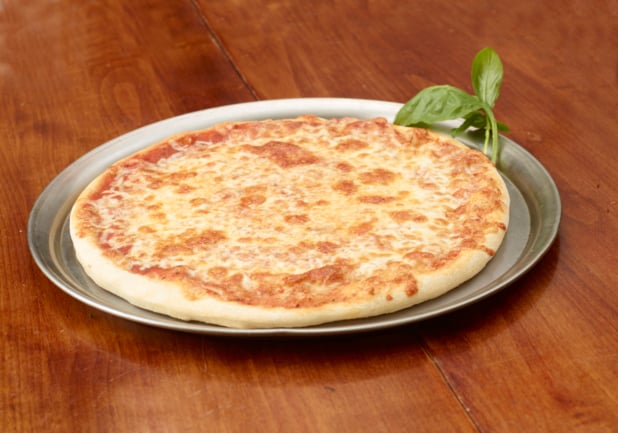 A Whole Cheese Pizza with Fresh Basil Garnish on a Silver Platter on a Wooden Table