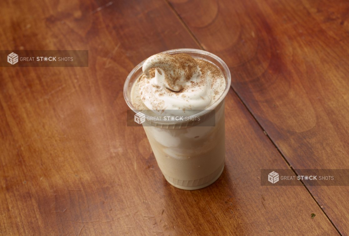 Frappuccino with Soft Serve Ice Cream in a Clear Plastic Take-Out Cup on a Wooden Surface