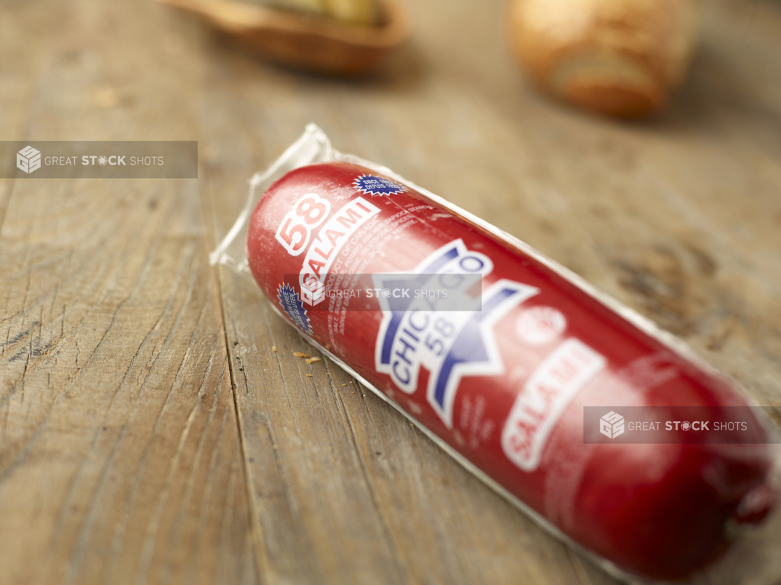 Close Up of a Package of Whole Salami on an Aged Wooden Table Surface