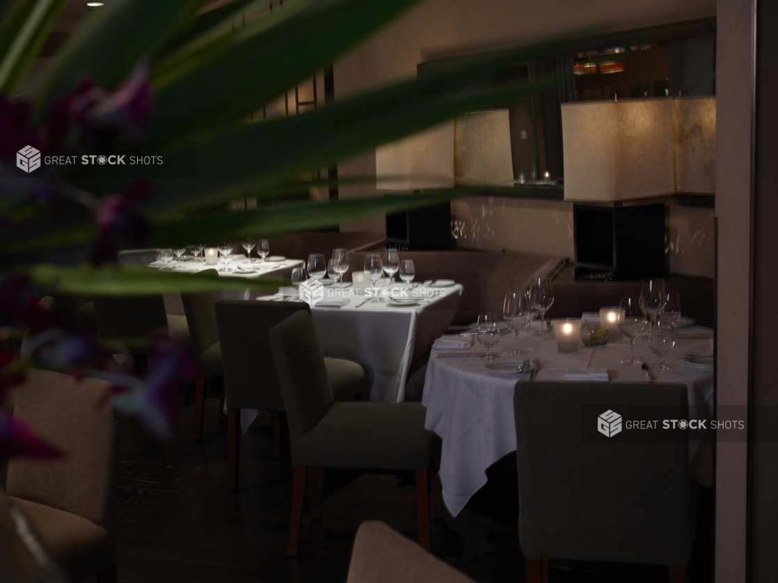 Interior of an elegant restaurant, tables set with white tablecloths and wine glasses