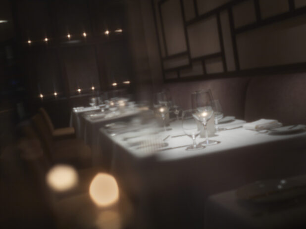 Interior of an elegant restaurant, tables set with white tablecloths and wine glasses,