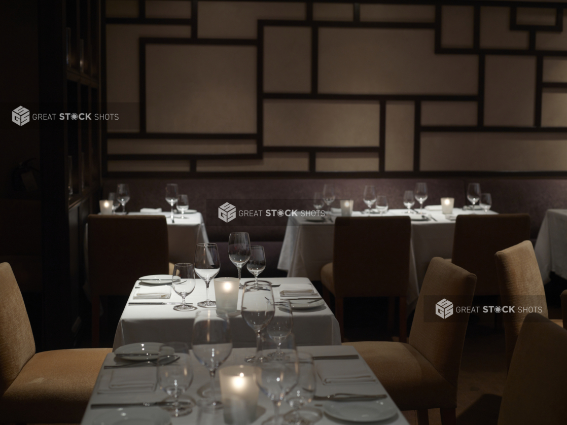 Interior of an elegant restaurant, tables set with white tablecloths and wine glasses