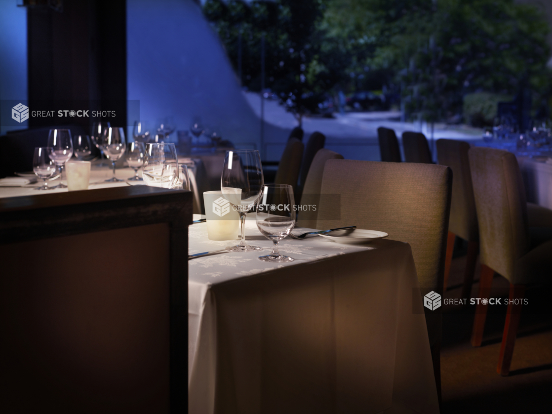 Interior of an elegant restaurant, tables set with white tablecloths and wine glasses