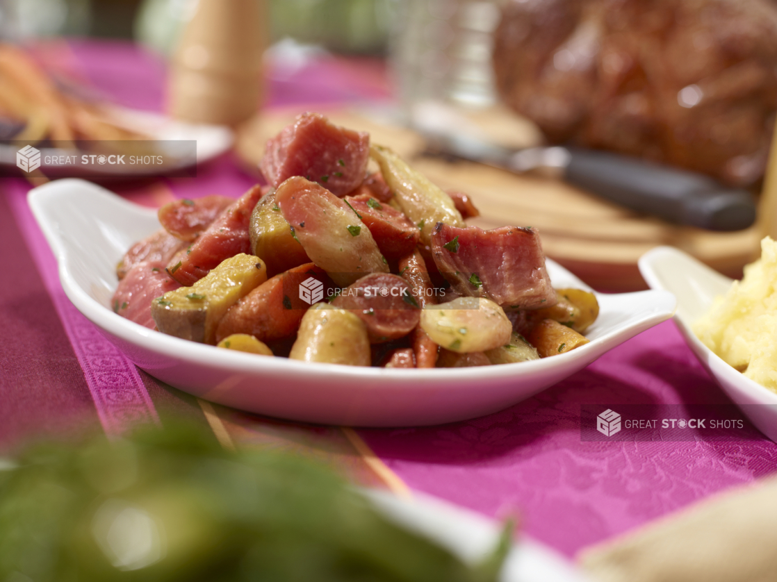 Warm Beets, Carrots and Potato Salad in a White Ceramic Dish on a Pink Tablecloth in an Outdoor Garden Setting