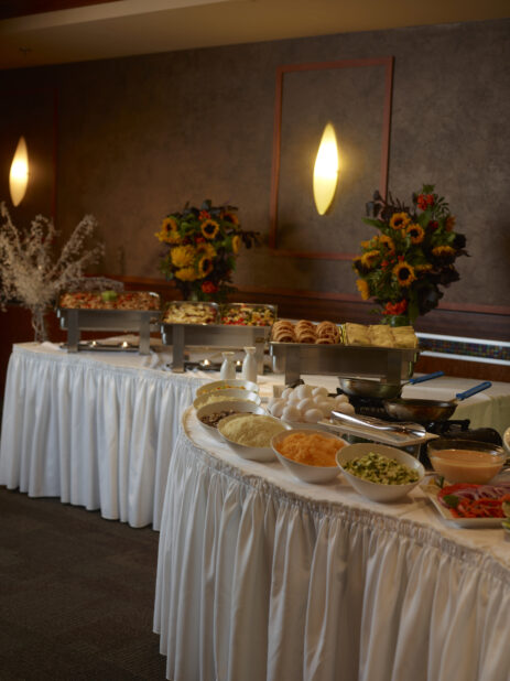 Buffet tables with steamers of breakfast food and an omelette station
