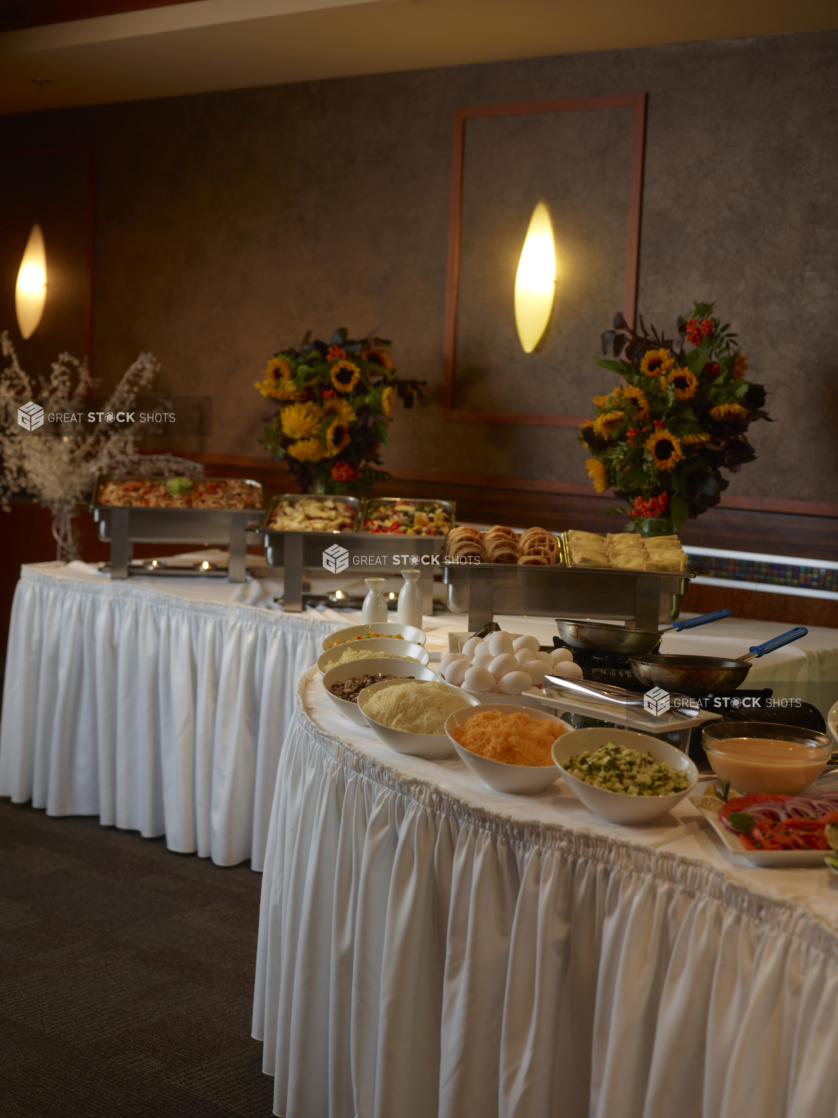 Buffet tables with steamers of breakfast food and an omelette station