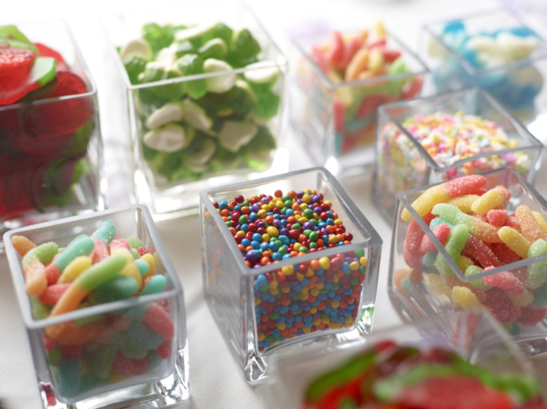 Gummy candy and sprinkles in cubic glass containers