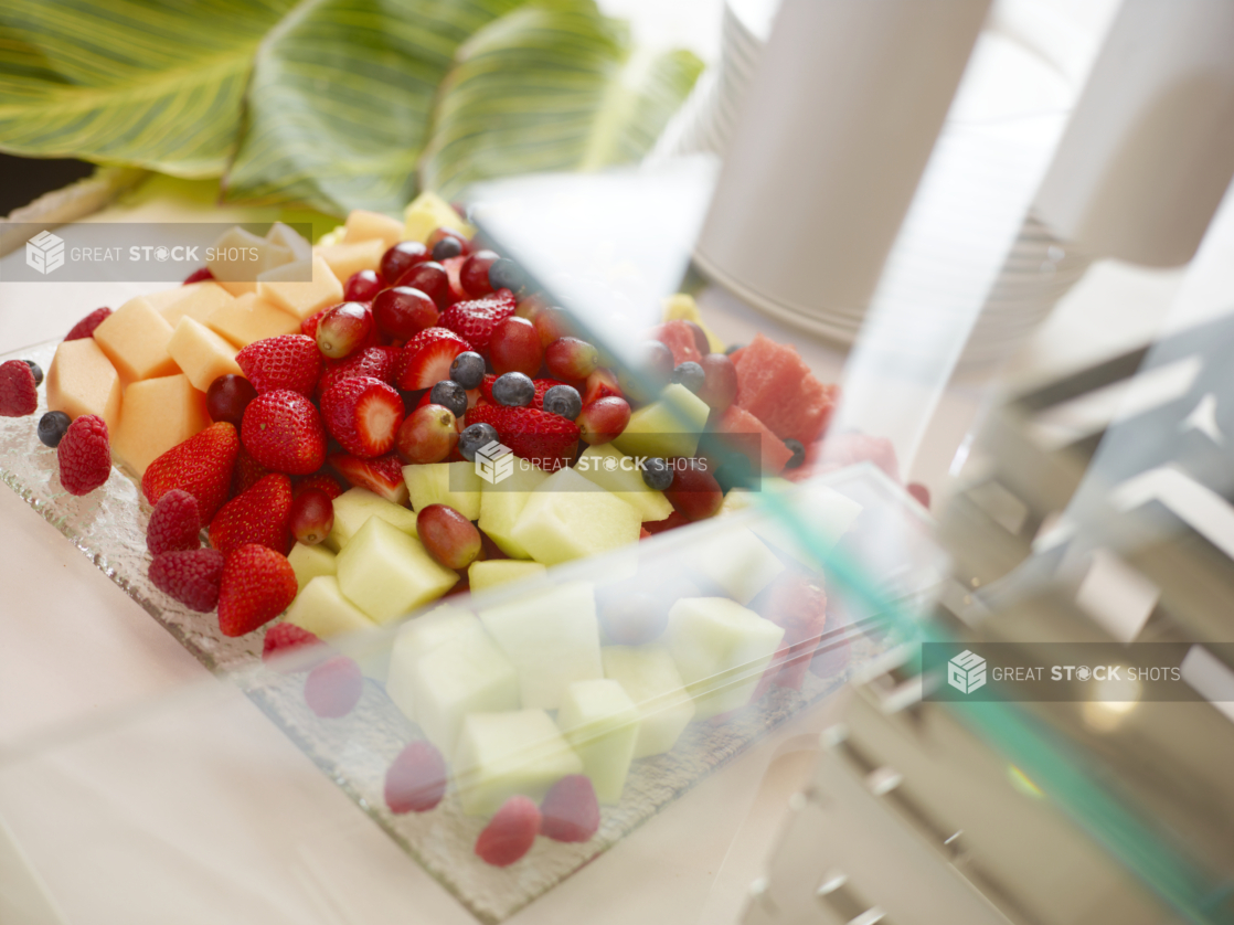 Fresh fruit platter with cubes of melon, whole strawberries, blueberries, and grapes