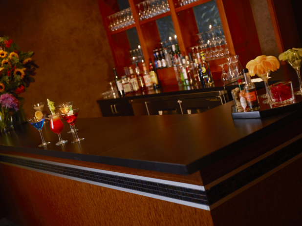 Elegant red-toned bar with colourful cocktails and a tray of garnishes