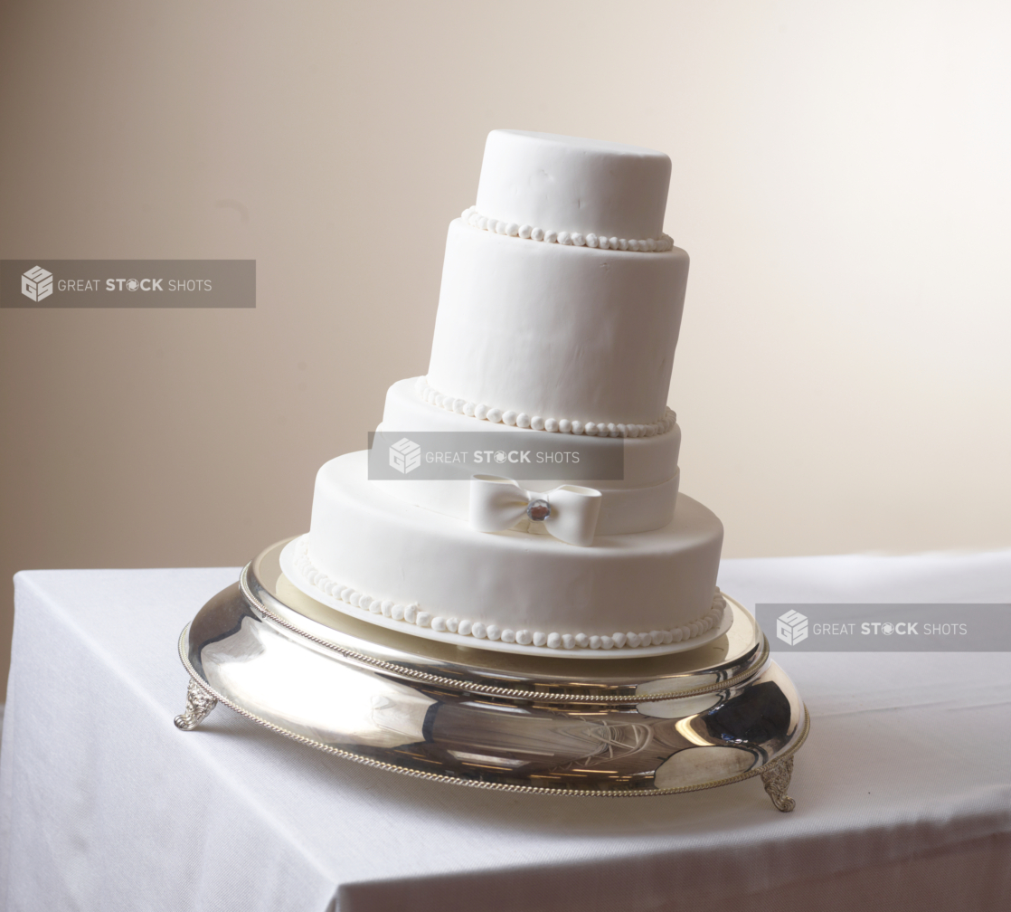 4 tier white wedding wedding cake on a silver cake stand