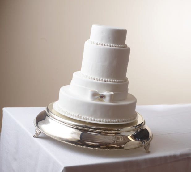 4 tier white wedding wedding cake on a silver cake stand