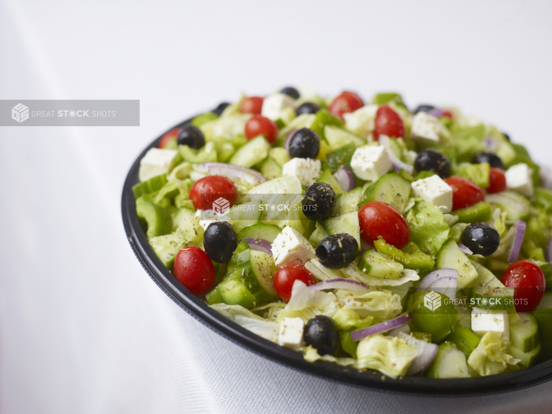 large catering greek salad with green peppers tomato black olives red onion dried oregano and feta cheese