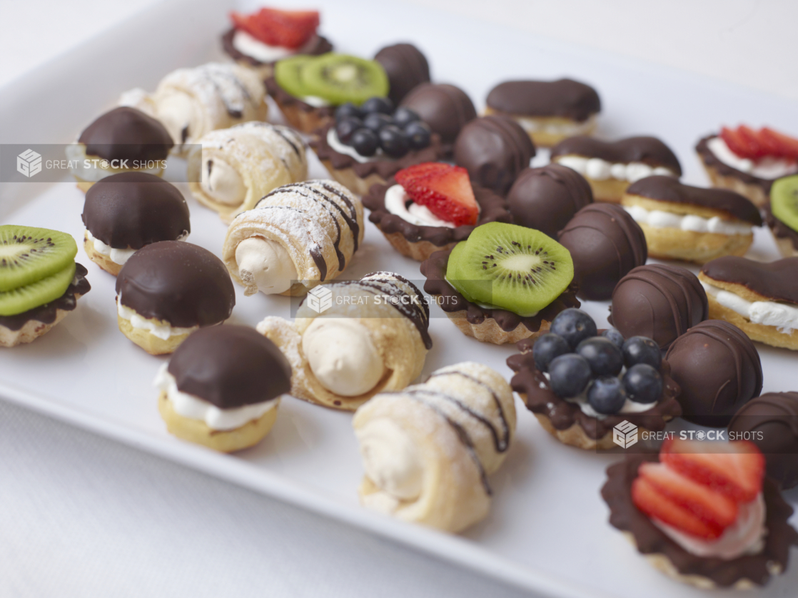 close up of assorted mini dessert tray on a white tray and white surface