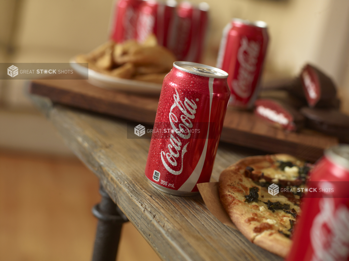 Cold cans of Coke interspersed with pizza and snack foods