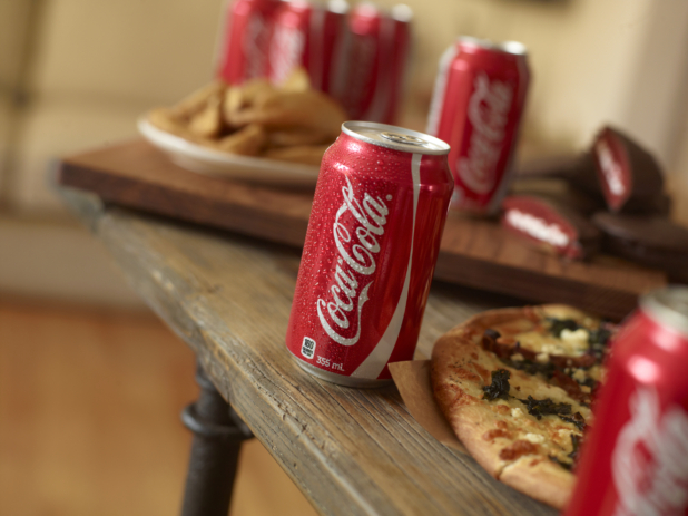 Cold cans of Coke interspersed with pizza and snack foods