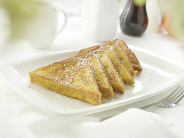 French toast on a square white plate in an all-white table setting