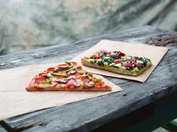 Jumbo Deluxe Pizza Slice and Romano Pizza al Taglio Slice on Kraft Paper on a Weathered Wooden Table