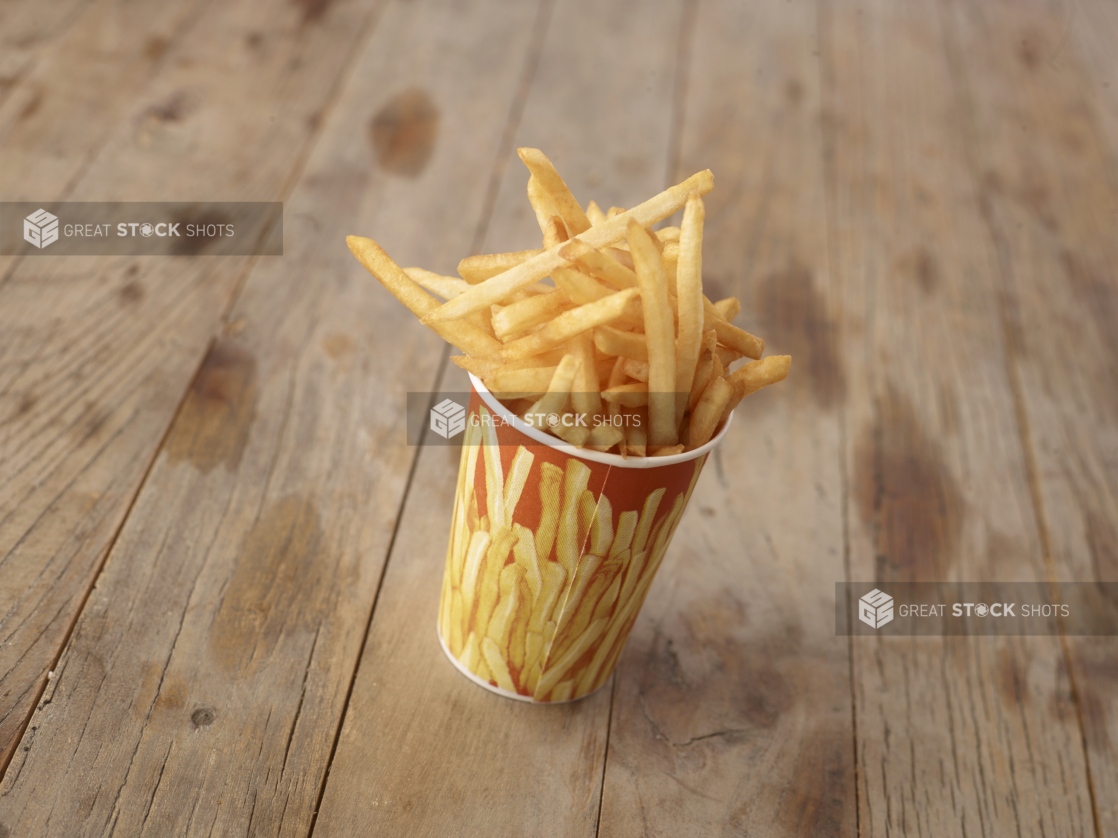 Cardboard Cup of Fresh, Thin-Cut French Fries on a Rustic Untreated Wood Surface