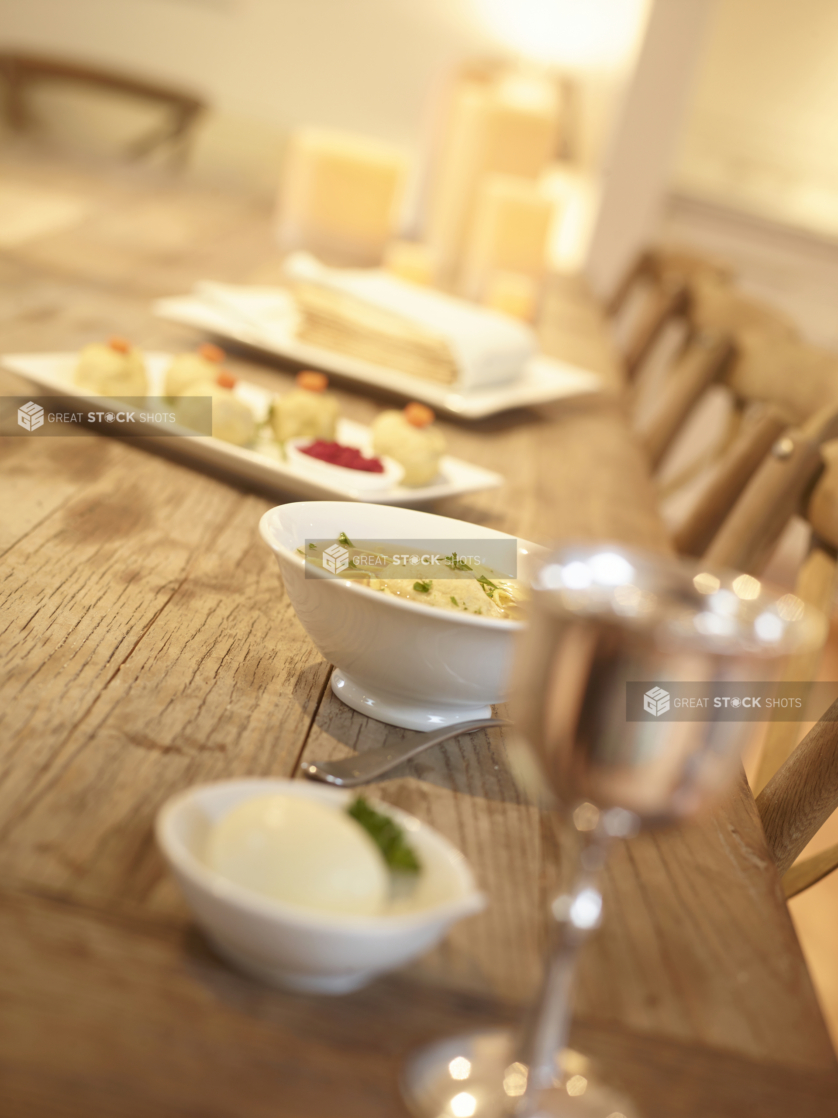 Rustic Wooden Table Set with Traditional Passover Dishes Such as Matzoh Ball Soup and Matzah Flatbread