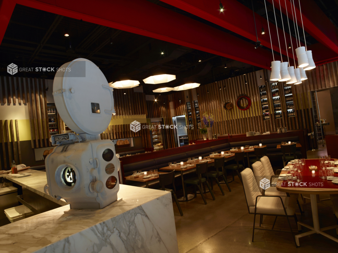 Main Dining Room Area with Wood Tables, Concrete Flooring, Wood Panelling, Marble Counter and Red Ceiling Beams