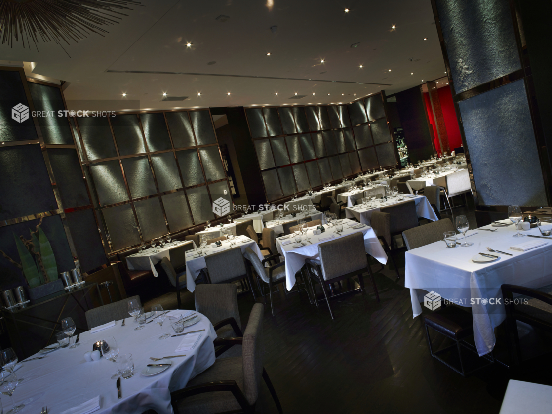 Classy, High-End Restaurant Interior with Formal Table Settings, Moody Lighting and a Large Circular Table for Group Dining